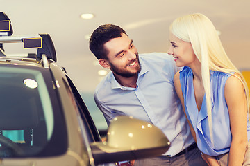 Image showing happy couple buying car in auto show or salon