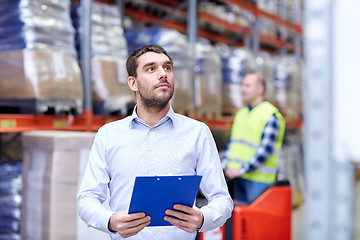 Image showing businessman with clipboard at warehouse