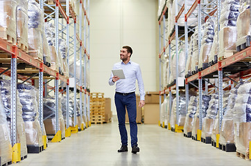 Image showing happy businessman with tablet pc at warehouse