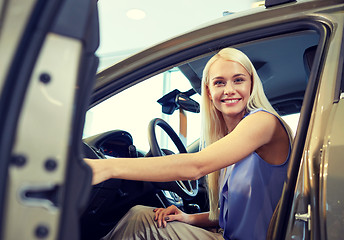 Image showing happy woman inside car in auto show or salon