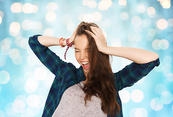 Image showing happy pretty teenage girl holding to head
