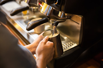 Image showing close up of woman making coffee by machine at cafe