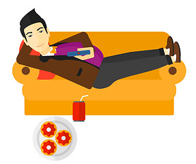 Image showing Man lying on sofa with junk food.