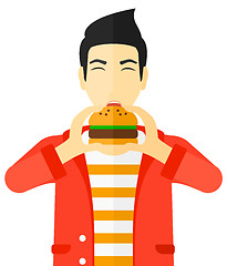 Image showing Man eating hamburger. 