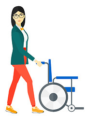 Image showing Woman pushing wheelchair.