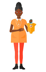 Image showing Pregnant woman with clothes for baby.