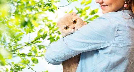 Image showing woman holding scottish fold cat over tree