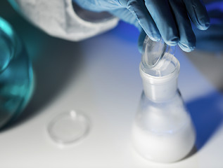 Image showing close up of hand pouring chemical into flask