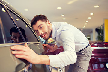 Image showing happy man touching car in auto show or salon