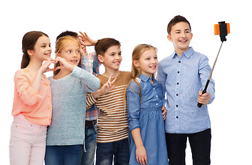 Image showing happy children with smartphone and selfie stick