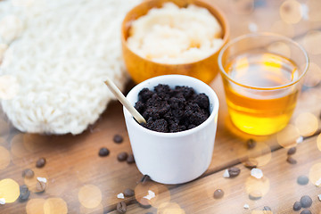 Image showing close up of coffee scrub in cup and honey on wood