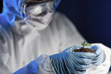 Image showing close up of scientist with plant and soil in lab