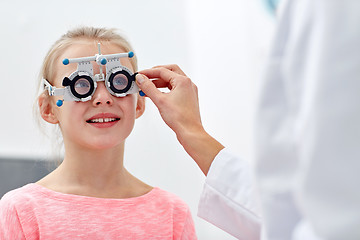 Image showing optician with trial frame and girl at clinic