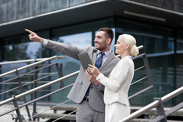 Image showing smiling businessmen with tablet pc outdoors