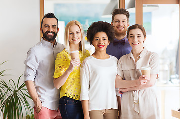 Image showing happy smiling creative team with coffee in office