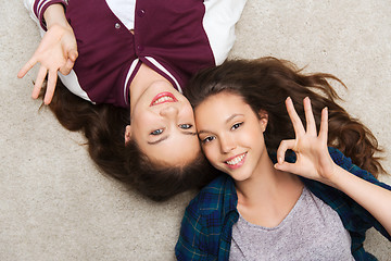 Image showing happy smiling pretty teenage girls lying on floor