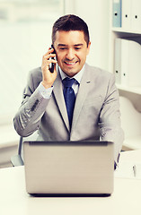 Image showing smiling businessman with laptop and smartphone