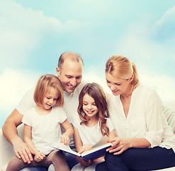 Image showing happy family with book at home