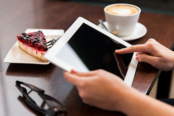 Image showing close up of hands with tablet pc, coffee and cake