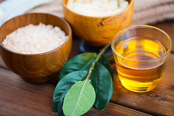 Image showing close up of honey in glass with pink salt on wood