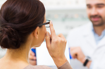 Image showing close up of woman choosing glasses at optics store