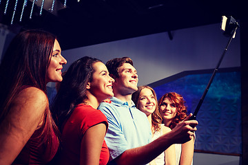 Image showing friends with smartphone taking selfie in club