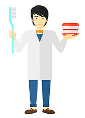 Image showing Dentist with dental jaw model and toothbrush.