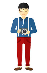 Image showing Smiling photographer holding camera.