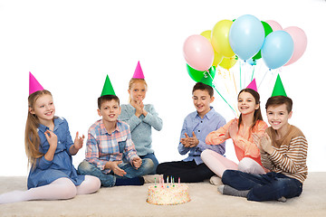 Image showing happy children in party hats with birthday cake