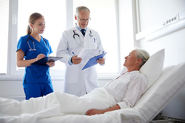 Image showing doctor and nurse visiting senior woman at hospital