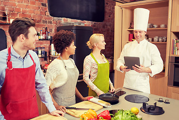 Image showing happy friends with tablet pc in kitchen