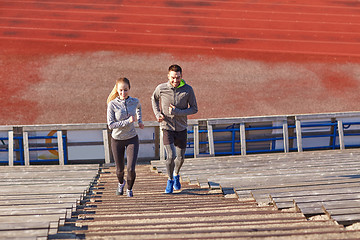 Image showing happy couple running upstairs on stadium