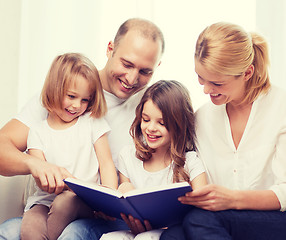 Image showing smiling family and two little girls with book