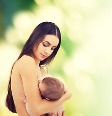 Image showing happy mother feeding her adorable baby