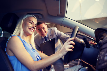 Image showing happy woman with car dealer in auto show or salon