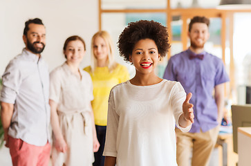 Image showing woman making handshake over creative office team