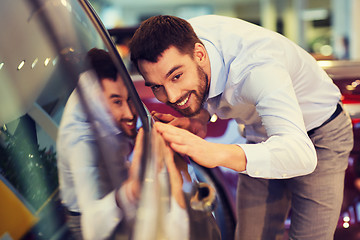 Image showing happy man touching car in auto show or salon