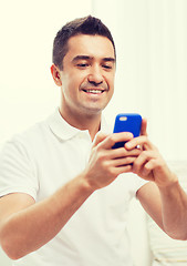 Image showing happy man with smartphone at home