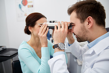 Image showing optician with pupilometer and patient at eye clinic