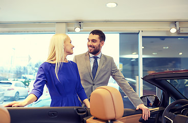 Image showing happy couple buying car in auto show or salon