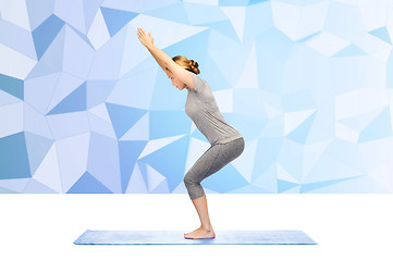 Image showing woman making yoga in chair pose on mat