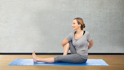 Image showing woman making yoga in twist pose on mat