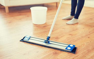 Image showing close up of woman with mop cleaning floor at home