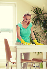 Image showing happy woman cleaning table at home kitchen