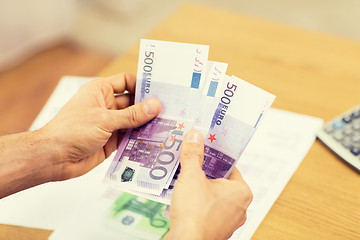 Image showing close up of man hands counting money at home