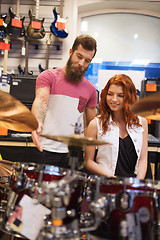 Image showing man and woman with drum kit at music store