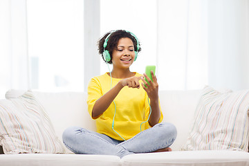 Image showing happy african woman with smartphone and headphones