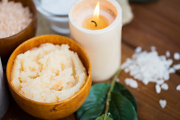 Image showing close up of natural body scrub and candle on wood