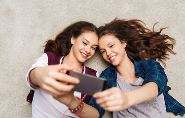 Image showing happy teenage girls on floor and taking selfie