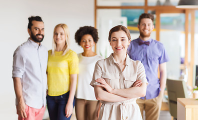 Image showing happy young woman over creative team in office